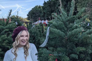 Patron of Shawn's Christmas Trees smiles before tree