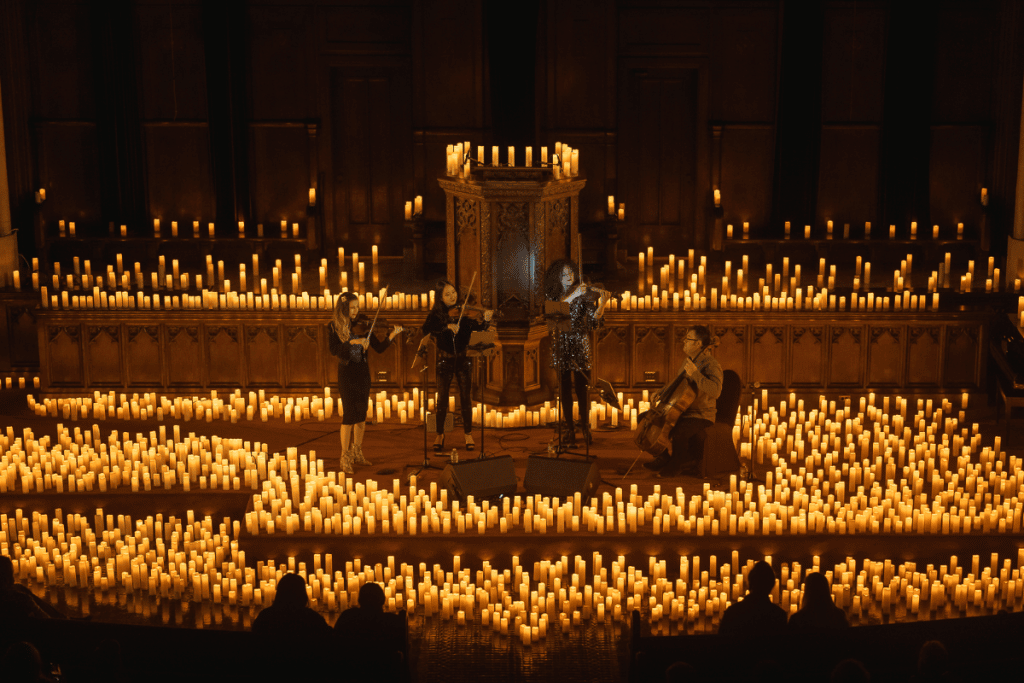 A string quartet performing on a stage covered in candles at Immanuel Presbyterian Church