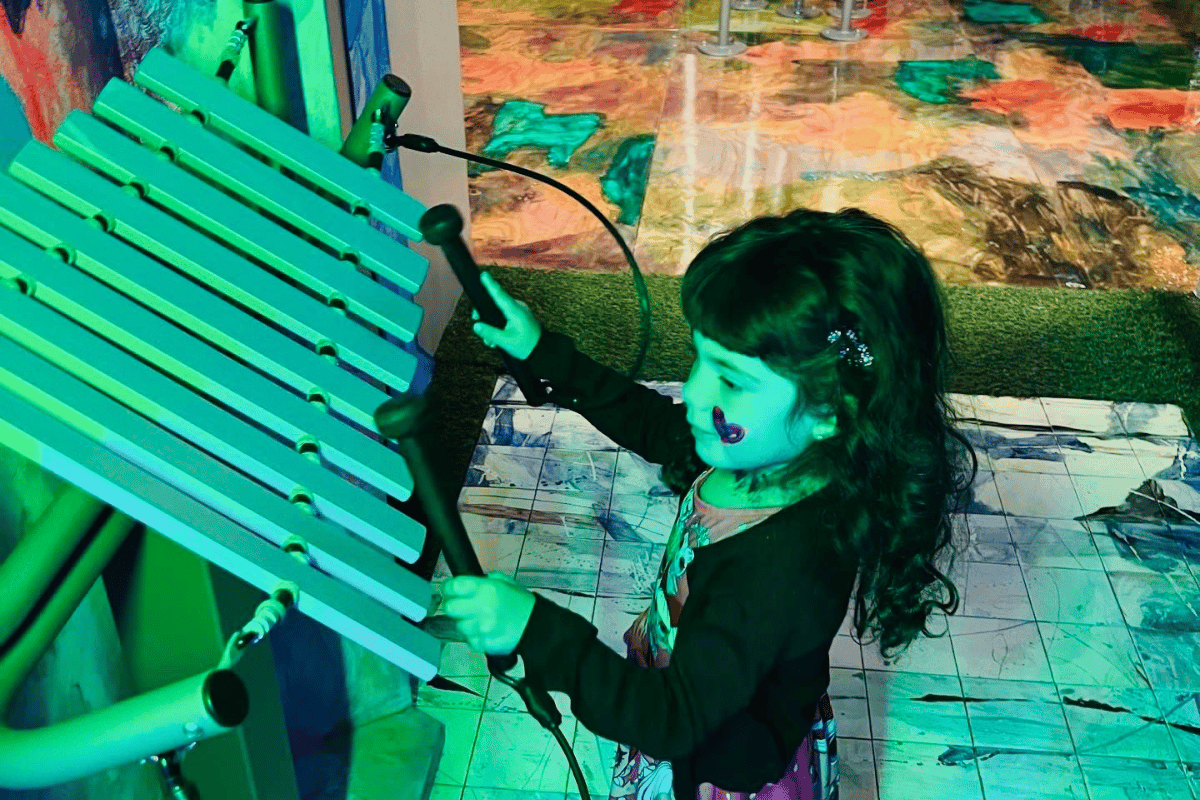 A young girl plays on an instrument