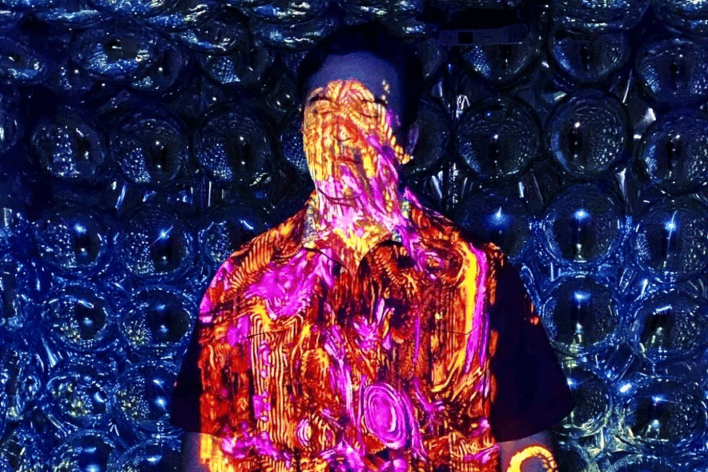 A man is bathed in multicolored light