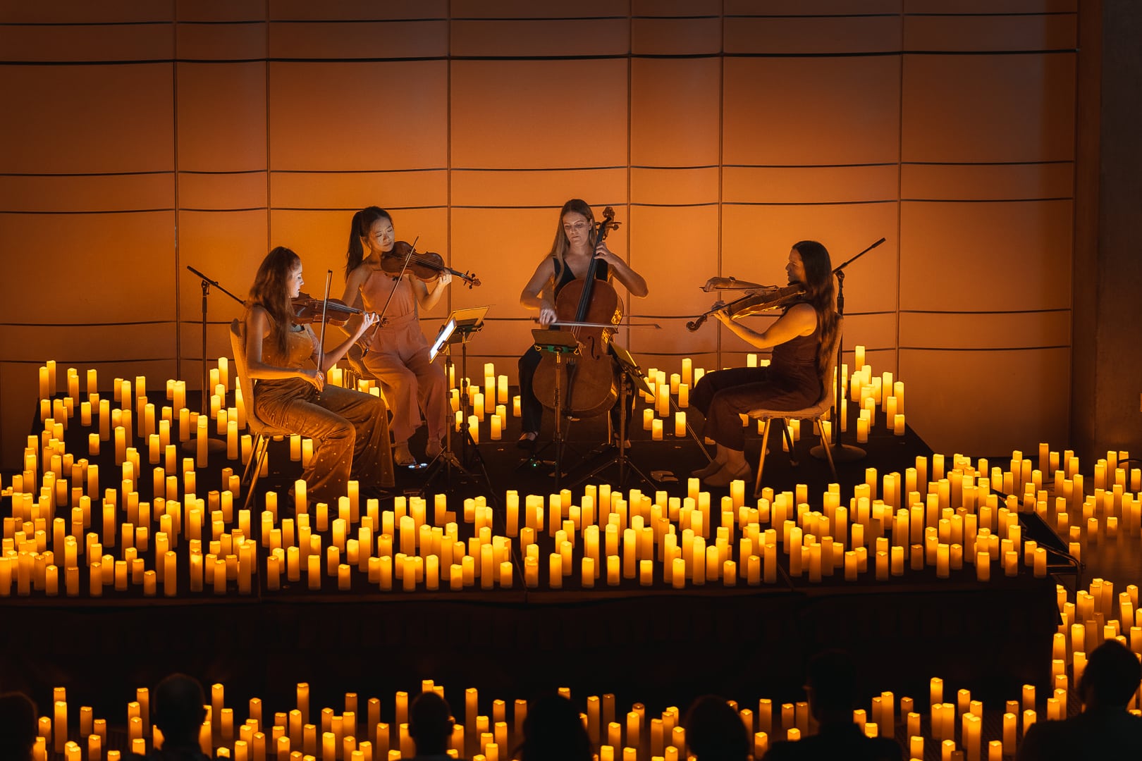 A string quartet performing surrounded by candles at a Candlelight concert in Los Angeles.