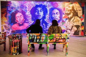 Guests at the Bob Marley One Love Experience look at street art of Bob Marley