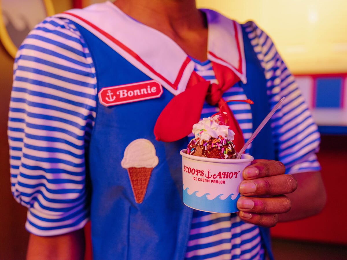 A Scoops Ahoy employee holds a cup of ice cream
