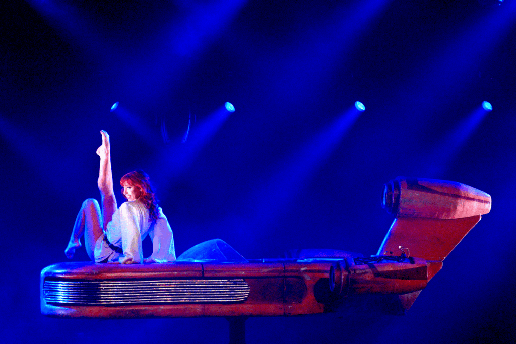A burlesque dancer performs on a sci-fi vehicle