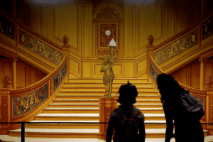 A person stands in front of the Titanic's Grand Staircase