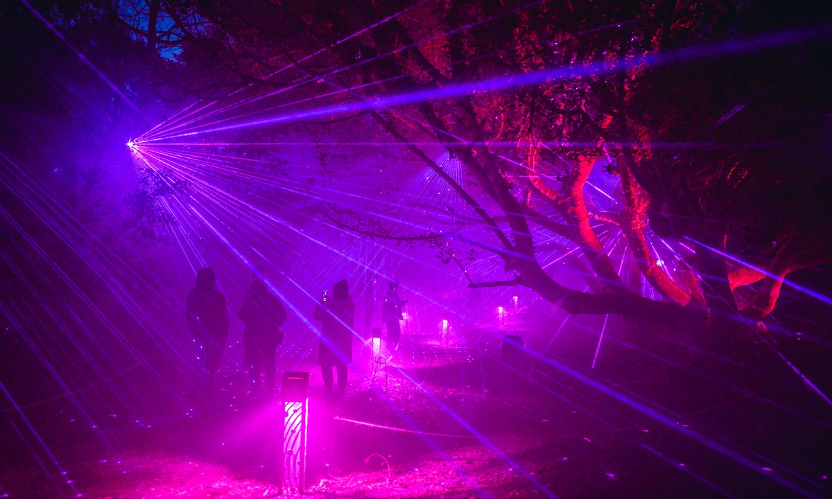 People walk through purple lights at Astra Lumina