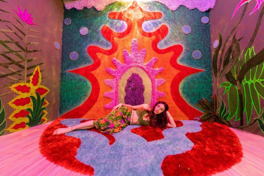 A woman lays on her side in a colorful room