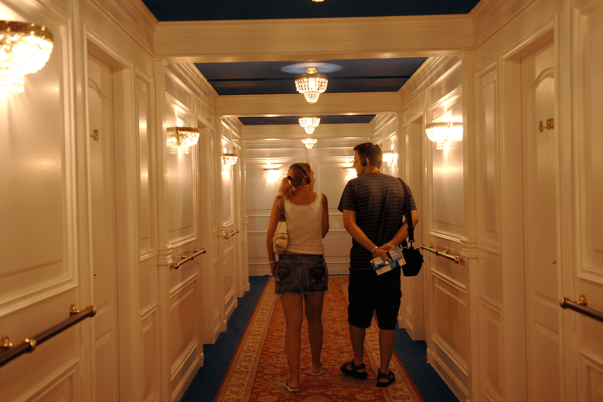 A man and a woman walk down a recreated part of the Titanic ship