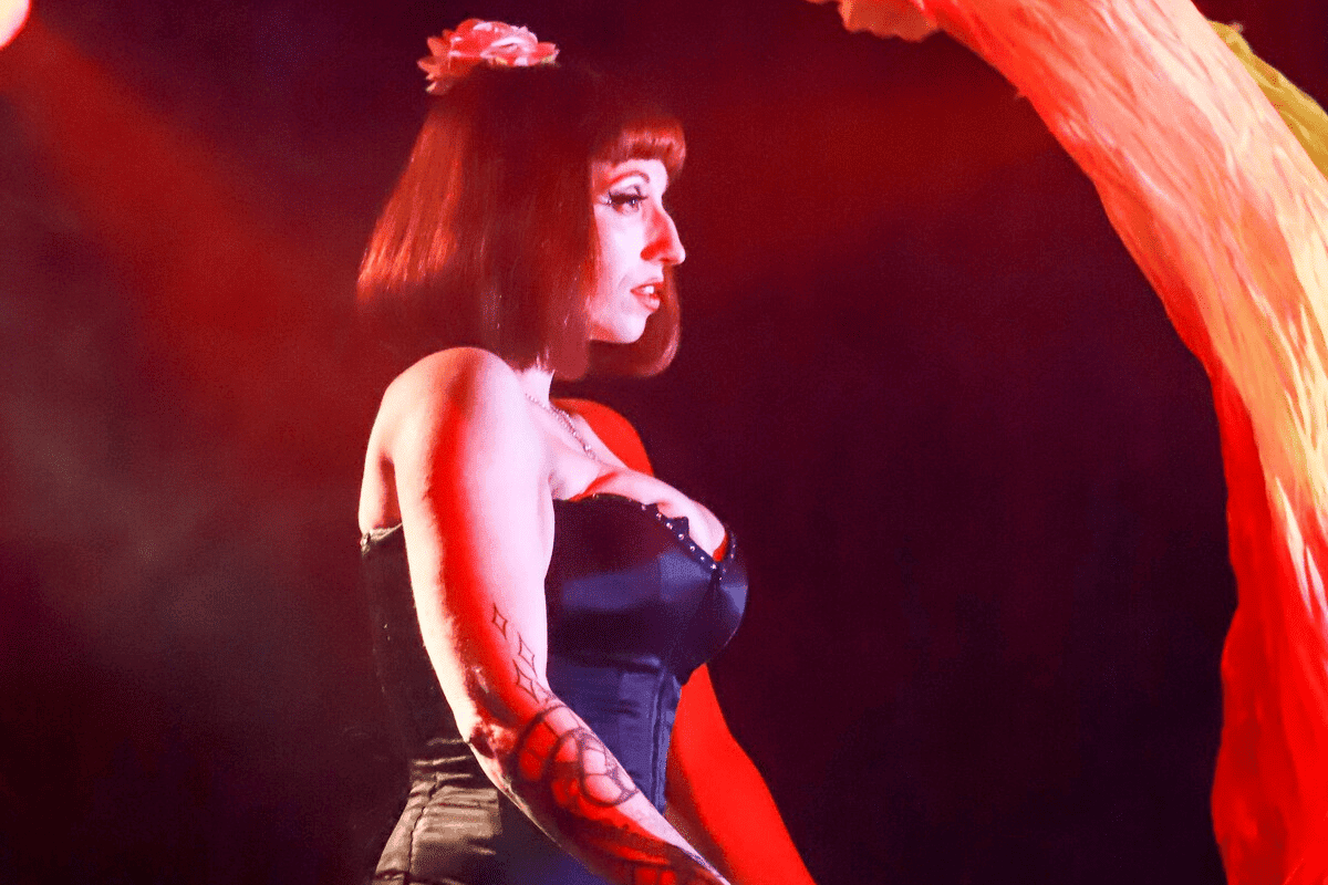 A burlesque dancer stands onstage
