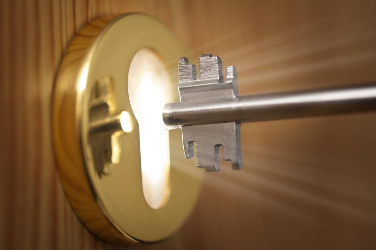 A key enters a keyhole shining with light
