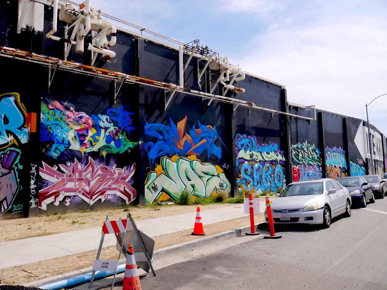 Dozens of graffiti tags line a wall