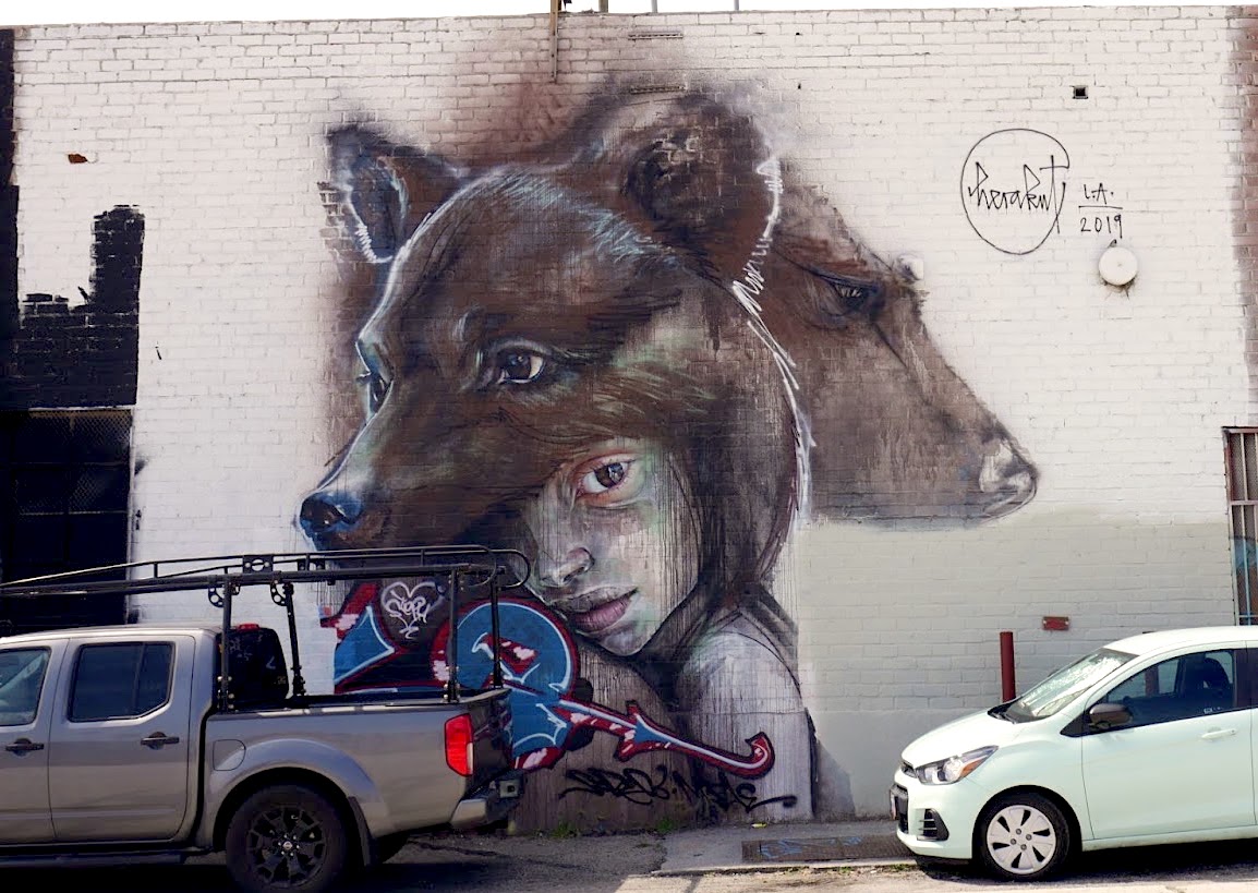 A mural of a young woman wearing a wolf's head on her own head