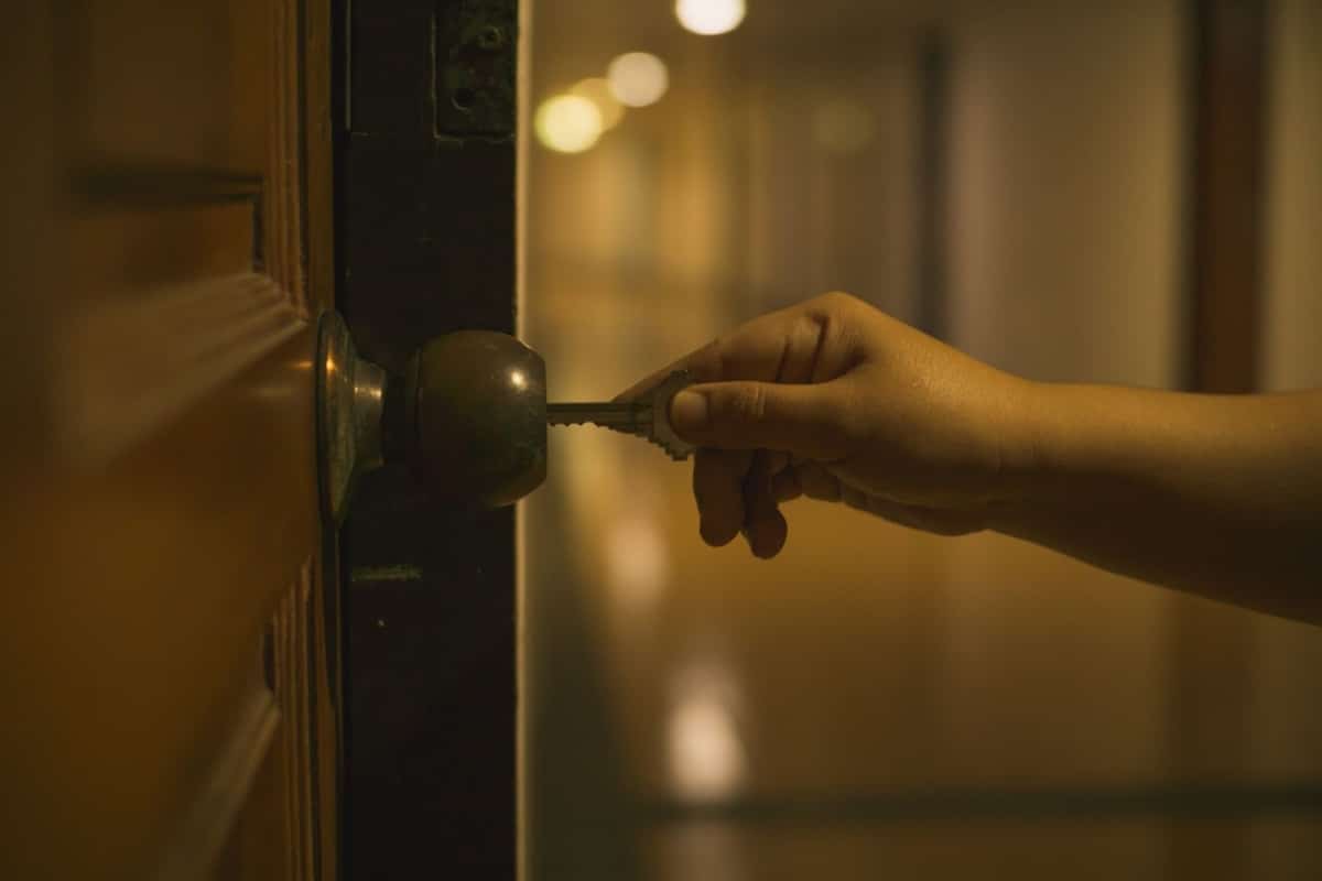 Someone unlocks their hotel room with a key