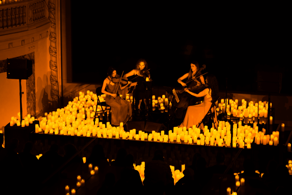 A string quartet perform by candlelight at a Candlelight concert.