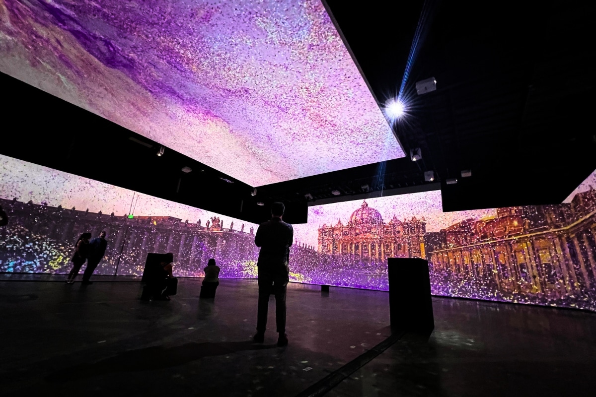 People stand among projected screens at Explore Vatican