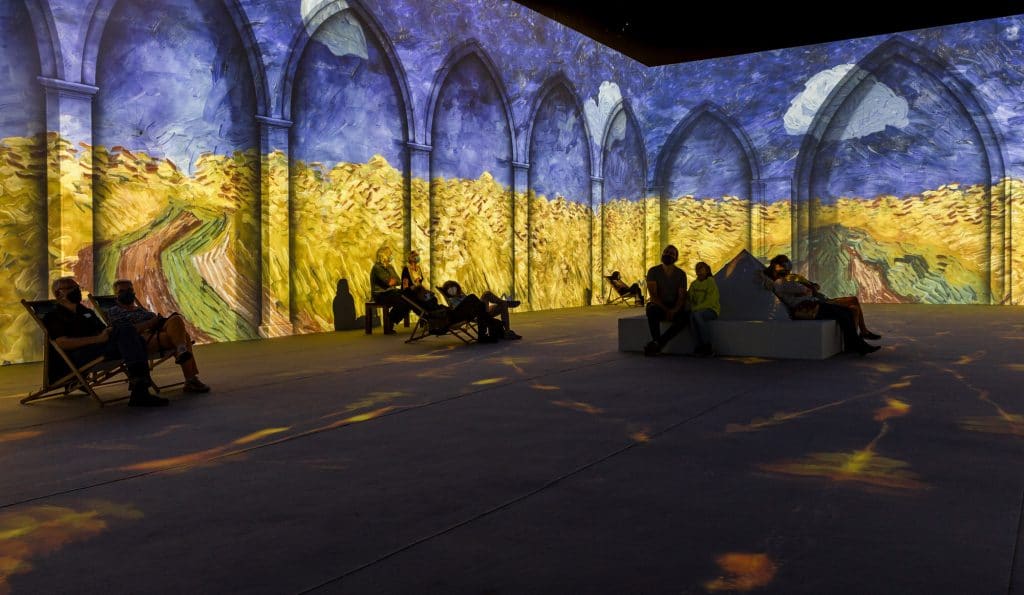 People sitting inside the Van Gogh Immersive Experience.