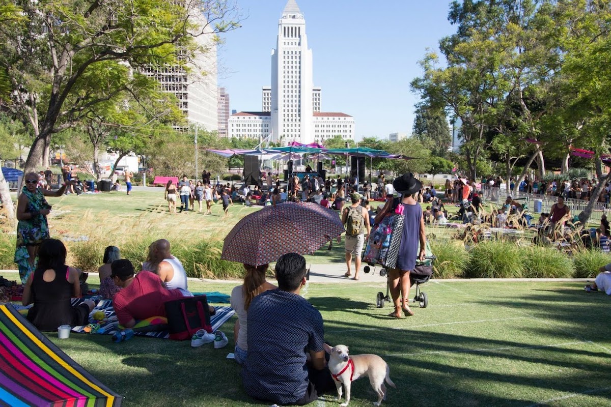 El césped de Grand Park lleno de personas caminando y haciendo picnic.