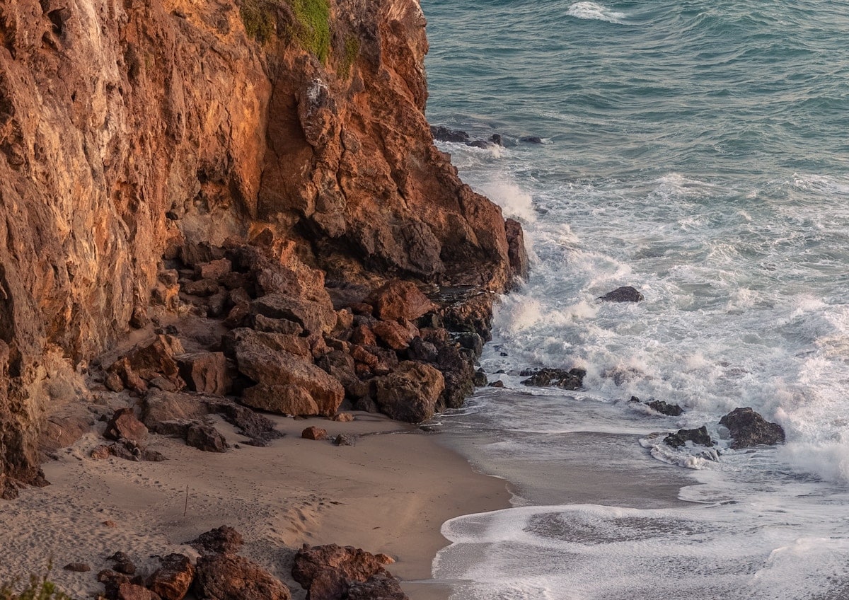 The rocky cliffs meeting the sea at Point Dume Beach.