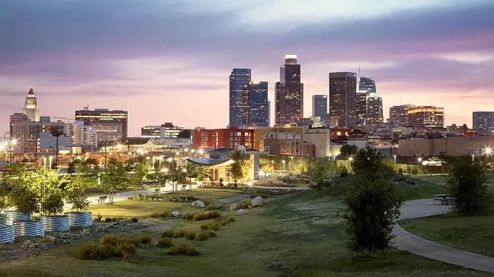 A view of the Los Angeles State Historic Park at dusk with the downtown skyline in the background.