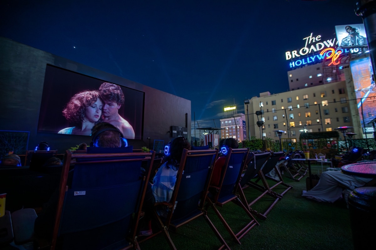 An audience watches a movie on a rooftop