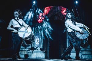 Two performers dress as vampires beat drums onstage