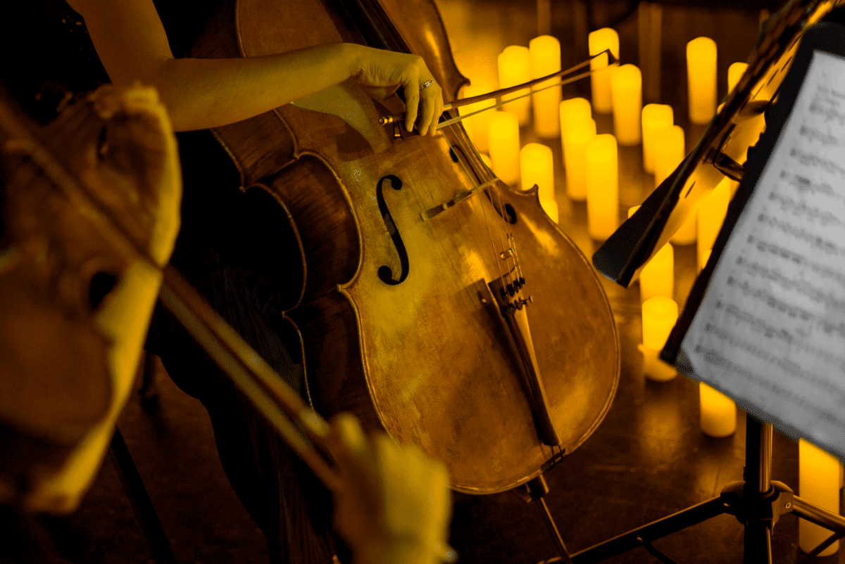 A musician playing the cello by candlelight. 