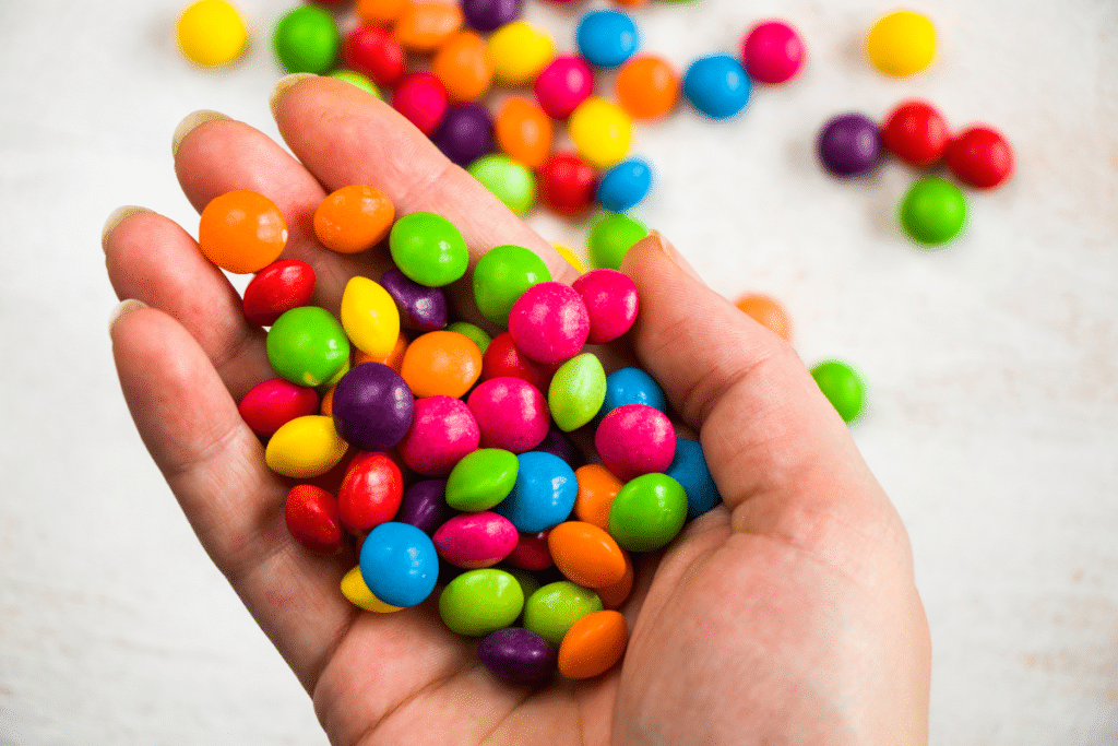person holding a handful of skittles