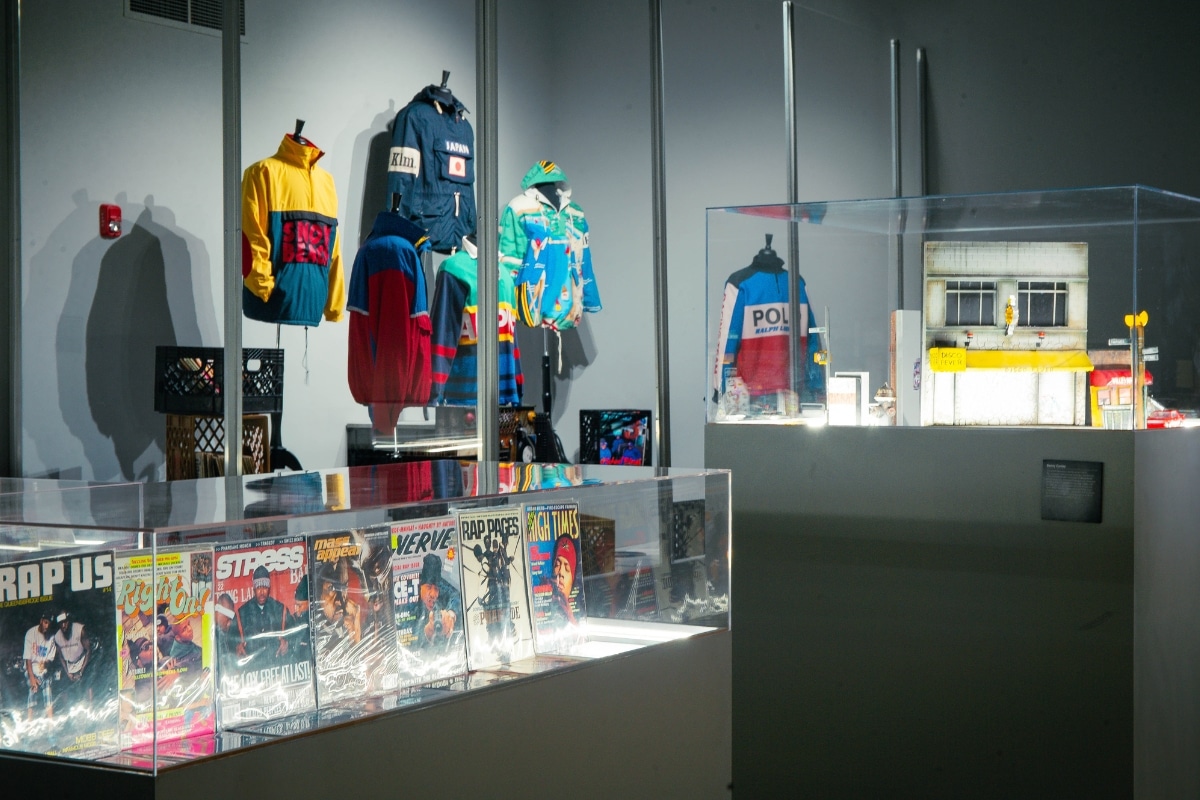An exhibit showing clothes and magazines related to hip hop